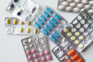 Colorful assortment of pills and capsules in blister packs for healthcare and medication usage.