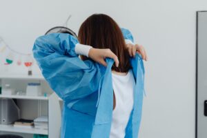 Back view of female scientist wearing lab coat in a laboratory setting.